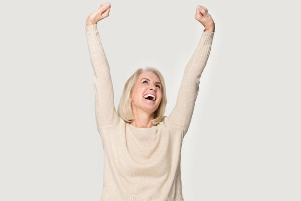 excited senior woman raised stretched hands feels happy studio shot - medial object imagens e fotografias de stock
