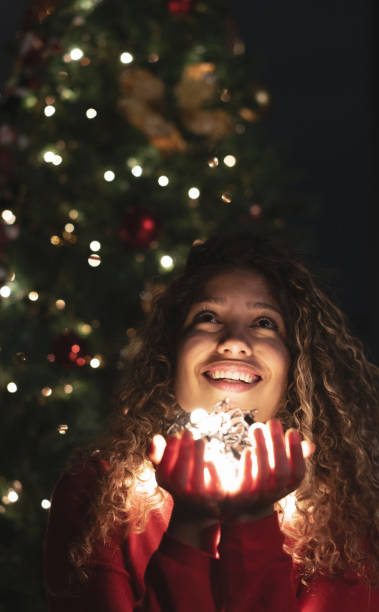 opgewonden vrouw versieren haar huis voor kerstmis - vrouw kerstboom versieren stockfoto's en -beelden