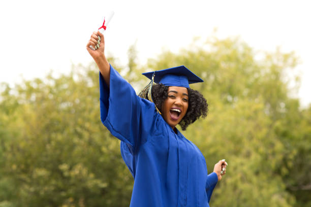 Excited young woman on graduation day. stock photo