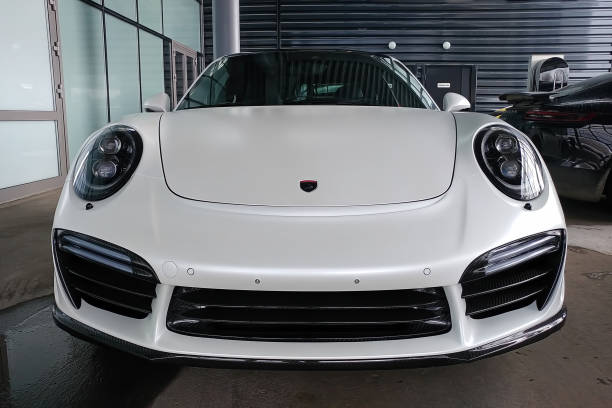 Exclusive white matte Porsche 911 turbo in exclusive wide and carbon body kit named Stinger from Topcar tuning. Parked on the street. Front hood view stock photo