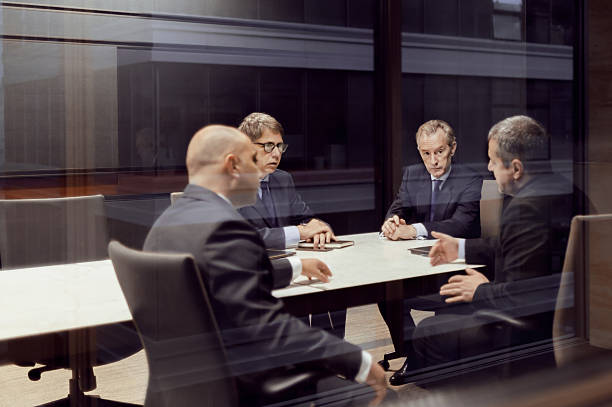 executive businessmen talking in meeting room - exclusief stockfoto's en -beelden