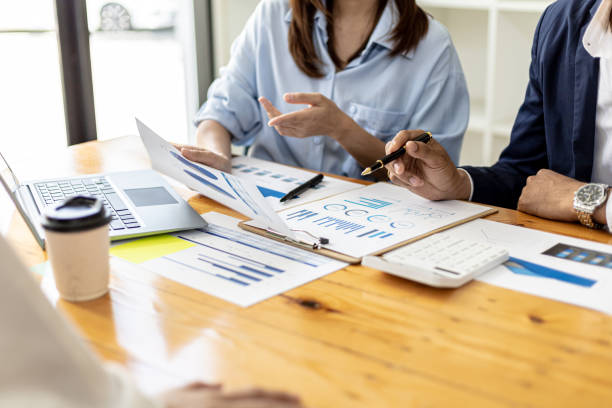 Executives and managers are meeting in a conference room, on the table there are some documents about the company's finances, managers are discussing financial information with the management. stock photo