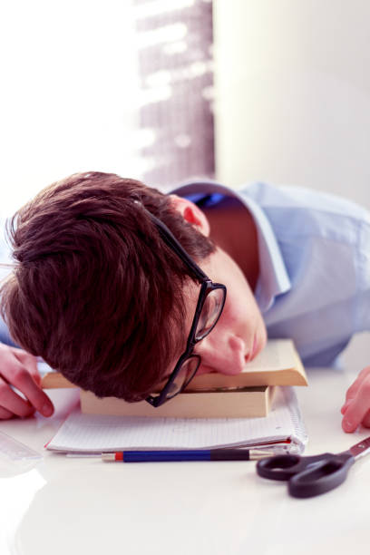 Exhausted student fell asleep on the books stock photo
