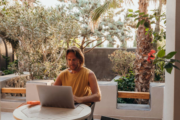 expatriate man working online on a computer, digital nomad concept - expatprogramma  stockfoto's en -beelden
