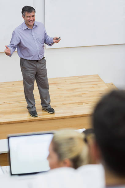 explaining leraar permanent in een collegezaal - man,standing, elevated view,remote control stockfoto's en -beelden