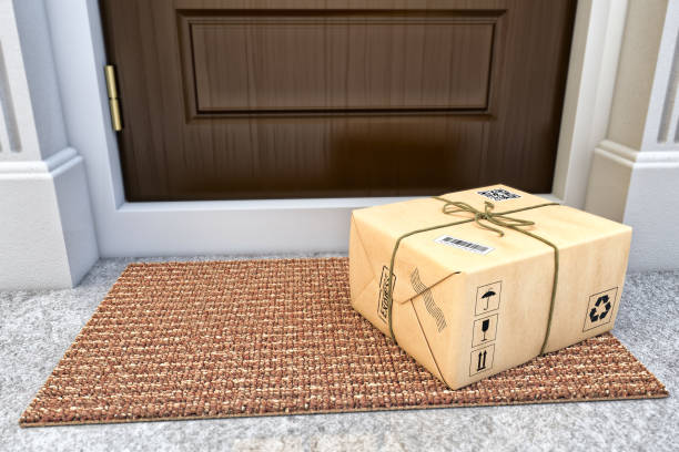 Express package delivery service concept Parcel box wrapped in craft paper on the door mat near the entrance door package stock pictures, royalty-free photos & images