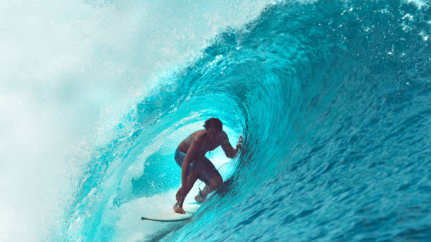 close-up: exreme atleta surfa uma onda do mar grande barril brilhar ao sol. - surf - fotografias e filmes do acervo