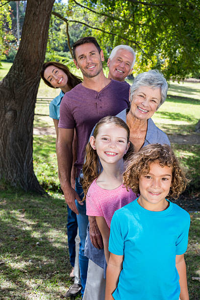 família alargada, sorridente no parque - grandparents vertical imagens e fotografias de stock