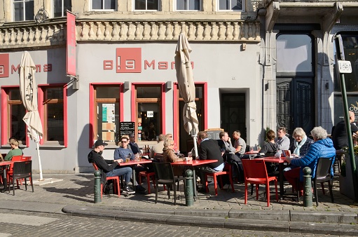 Brussels, Belgium - March 29, 2019: People at exterior pub in the old town of Brussels, Belgium.