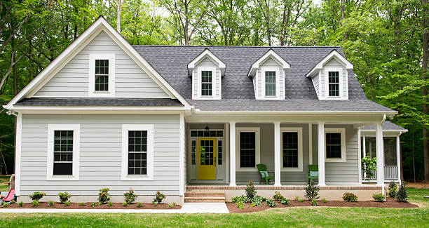 Exterior of New Suburban House Exterior of a new Cape Cod styled suburban house with recently planted shrubs and grass outdoors stock pictures, royalty-free photos & images