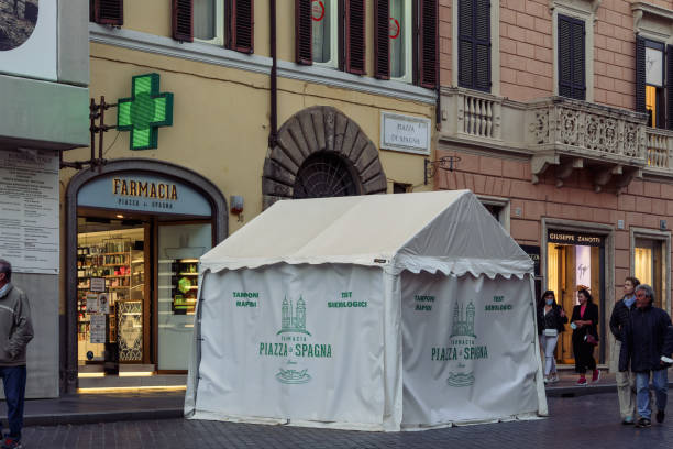 External day view of Italian pharmaceutical shop with illuminated green display also conducting quick swabs. stock photo