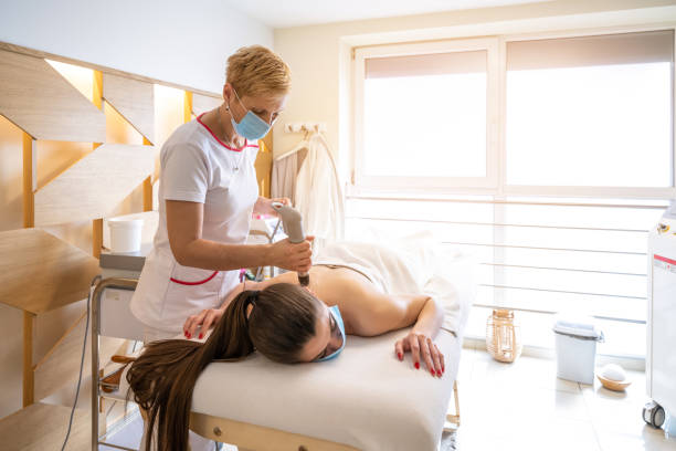 Extracorporeal shockwave therapy in beauty salon. stock photo