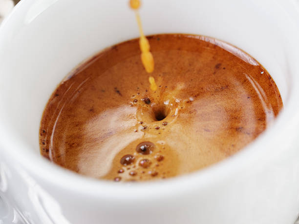 extraction of espresso with rich crema in cup - espresso stockfoto's en -beelden