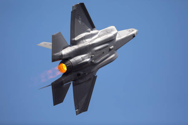 extremely  close tail view of an f-35 lightning ii  in a high g turn, with afterburner on - f 35 imagens e fotografias de stock