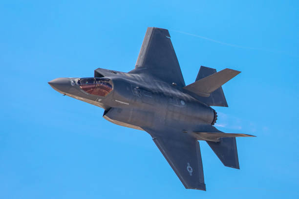 extremely close view of an f-35 lightning ii in a tight turn, with afterburner on - f 35 imagens e fotografias de stock