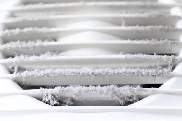 Extremely dirty and dusty white plastic ventilation air grille at home close up, harmful for health stock photo
