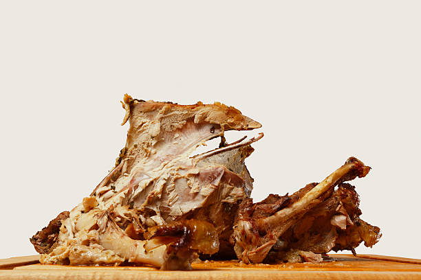 Eye Level View of Turkey Carcass on Cutting Board The remains of a roasted Thanksgiving turkey on a wooden cutting board. leftovers stock pictures, royalty-free photos & images