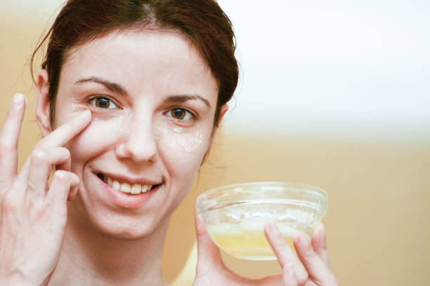 Eye treatement Redhead, caucasian model using albumen or egg white to relieve her dark circles egg white face mask stock pictures, royalty-free photos & images