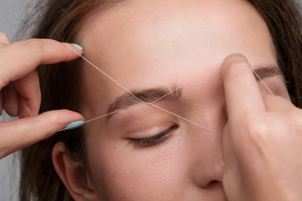 Close-up of female face during eyebrow correction procedure