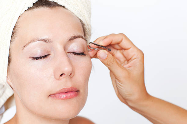 eyebrows being plucked stock photo
