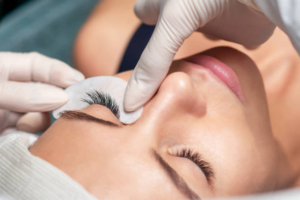Eyelash extension procedure. Young woman receiving extending the eyelashes in a beauty salon, close up, eyelash extension procedure. eyelash stock pictures, royalty-free photos & images