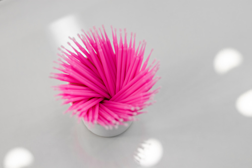 Eyelash microbrush applicators. Pink microbrushes in a glass. Consumables. Microbrushes are used in the beauty industry and dentistry