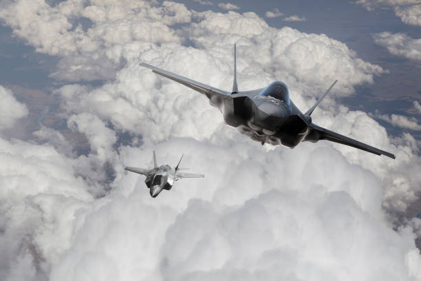 f-35 fighter jet flying over the clouds - f 35 imagens e fotografias de stock
