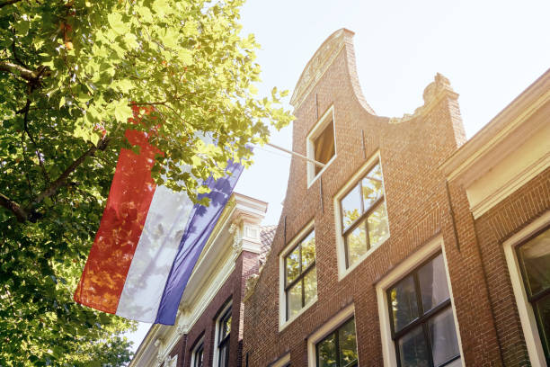 fassade des hauses in den niederlanden mit niederländischer flagge - holländische flagge stock-fotos und bilder