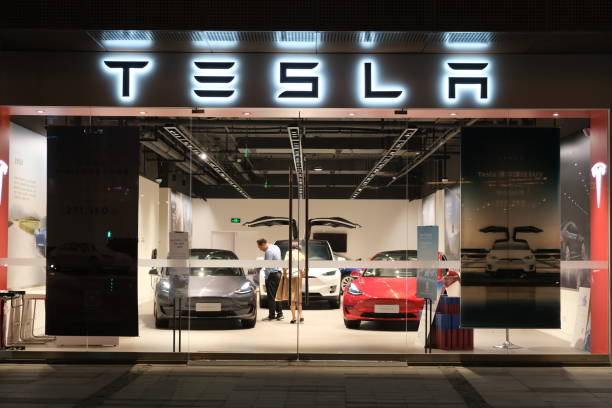 facade Tesla store with customers inside at night in China Shanghai/China-Sep.2020: facade Tesla store at night. customers inside Tesla retail shop choosing electric cars tesla motors stock pictures, royalty-free photos & images