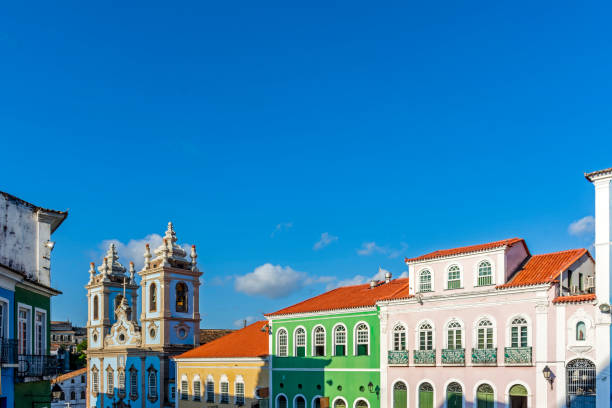 Facades of colorful houses and tower of an old baroque church in Pelourinho Facades of colorful houses and tower of an old baroque church in Pelourinho, the famous historic center of Salvador, Bahia pelourinho stock pictures, royalty-free photos & images