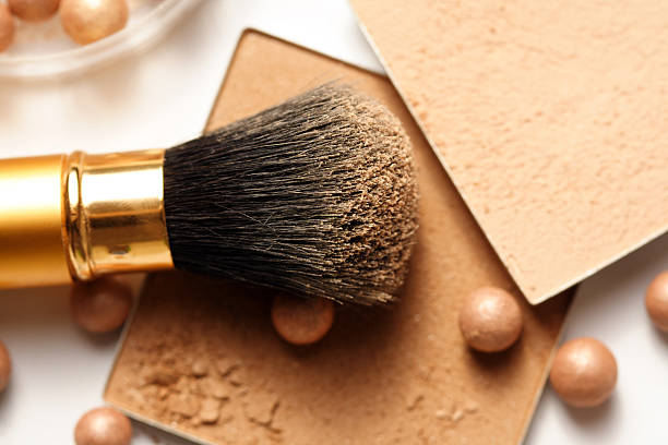 A face powder brush on top of face powder stock photo