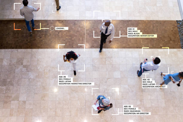 Facial recognition technology reveals information about diverse businesspeople While walking through an office lobby, diverse group of business professionals are identified by facial recognition technology, The information includes personal as well as professional information. lobby photos stock pictures, royalty-free photos & images