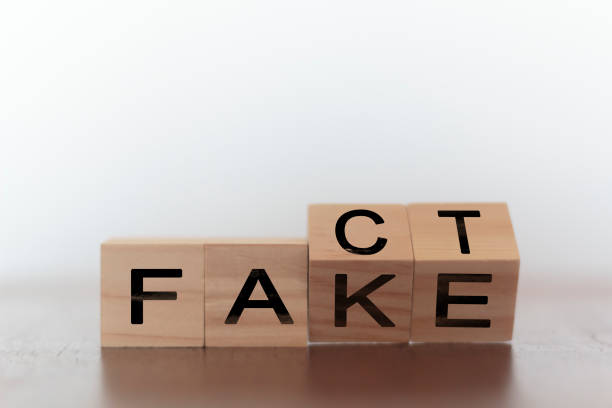 Fact and fake on words on wooden cubes stock photo
