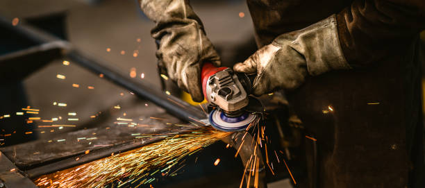Factory worker grinding a metal,close up Heavy industry worker grinds steel with an angle grinder,sparks flying,close up. steel mill stock pictures, royalty-free photos & images
