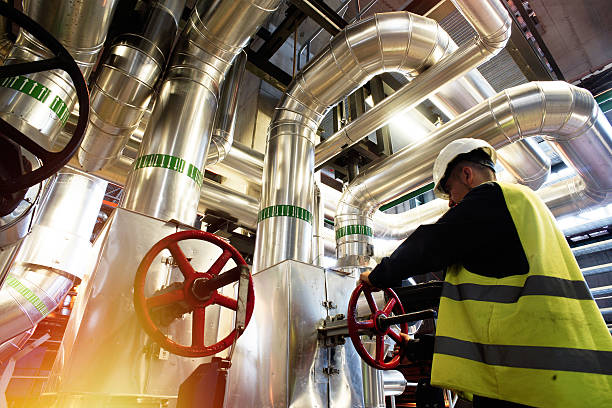 factory worker turning valve modern factory worker turning valve petroleum engineering stock pictures, royalty-free photos & images