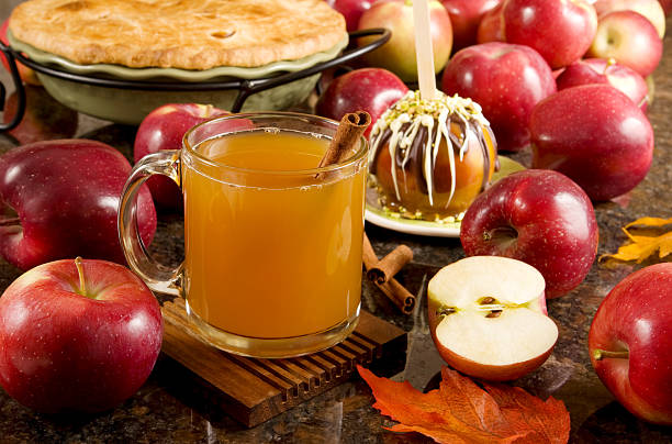Fall is here Delicious hot, spiced apple cider  A cup of hot apple cider, caramel apple and apple pie surrounded by fresh fruits cider stock pictures, royalty-free photos & images