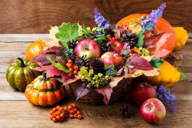 Fall table centerpiece with blue flowers Fall wicker basket table centerpiece with apples and blue flowers. Thanksgiving greeting background centerpiece stock pictures, royalty-free photos & images