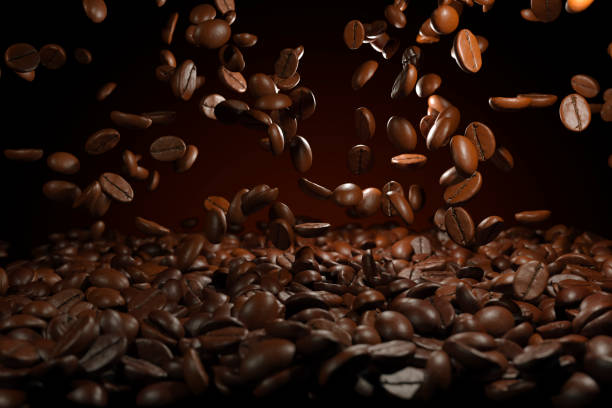 Falling roasted coffee beans on brown background stock photo