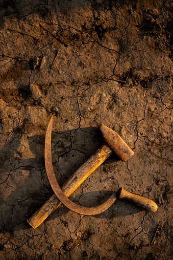 rusting hammer and sickle on arid ground, depicting the falling of the Soviet Union or USSR