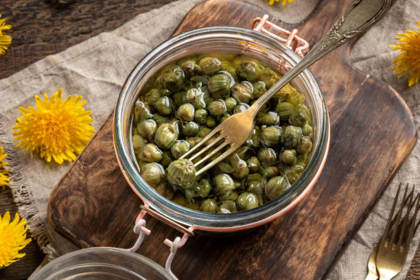 False capers made from young dandelion buds False capers made from young dandelion buds in a glass jar caper stock pictures, royalty-free photos & images