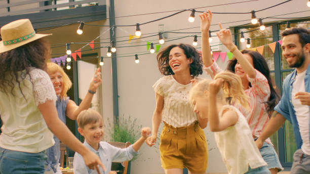 familie en vrienden dansen samen bij de tuin partij viering. jonge en oudere mensen plezier op een zonnige zomerdag disco. - family garden,party stockfoto's en -beelden