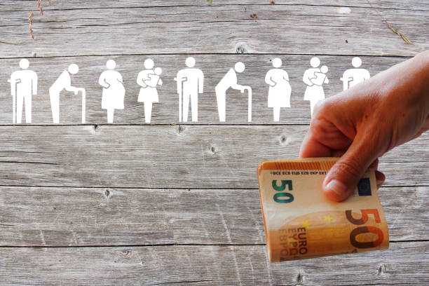 Family and Weak social categories welfare concept on wooden background with Euros in hand stock photo