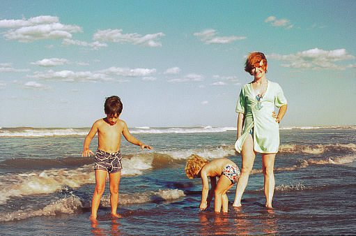 Vintage photo from the seventies of a family in the beach.