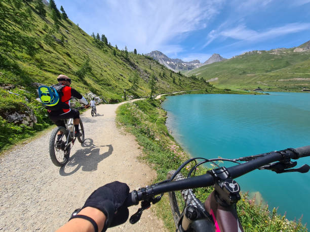 Family biking by the lake Tignes high up in the French Alps stock photo