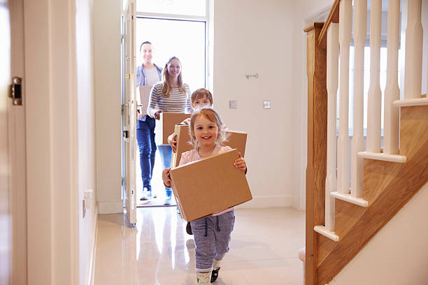Family Carrying Boxes Into New Home On Moving Day Family Carrying Boxes Into New Home On Moving Day unpacking stock pictures, royalty-free photos & images