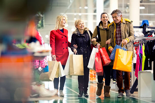 Family carrying shopping bags in mall stock photo