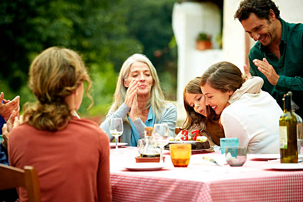 Family celebrating birthday at outdoor meal table Happy multi-generation family celebrating birthday at outdoor meal table in yard happy birthday wine bottle stock pictures, royalty-free photos & images