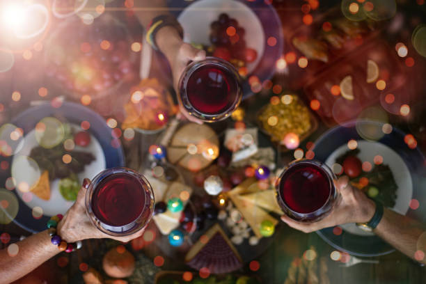 Family Christmas dinner for a celebration with red wine and cheers. Top view of a family Christmas dinner (meal) with togetherness party social event stock pictures, royalty-free photos & images