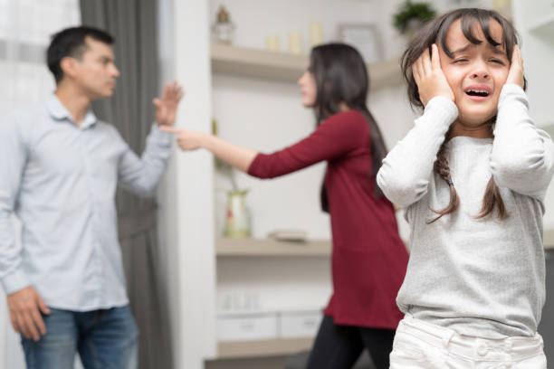 Family conflict concept Sadness little girl against blured of mother and father with quarrel at home. domestic violence stock pictures, royalty-free photos & images