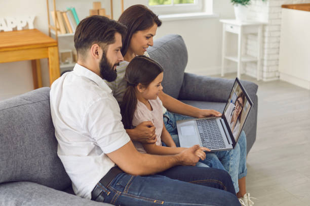 lekarz rodzinny online. szczęśliwa rodzina konsultuje się za pomocą komputera wideokonferencji w domu. - video call zdjęcia i obrazy z banku zdjęć